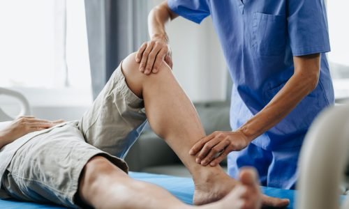 Close up of Physiotherapist working with patient on the bed in clinic